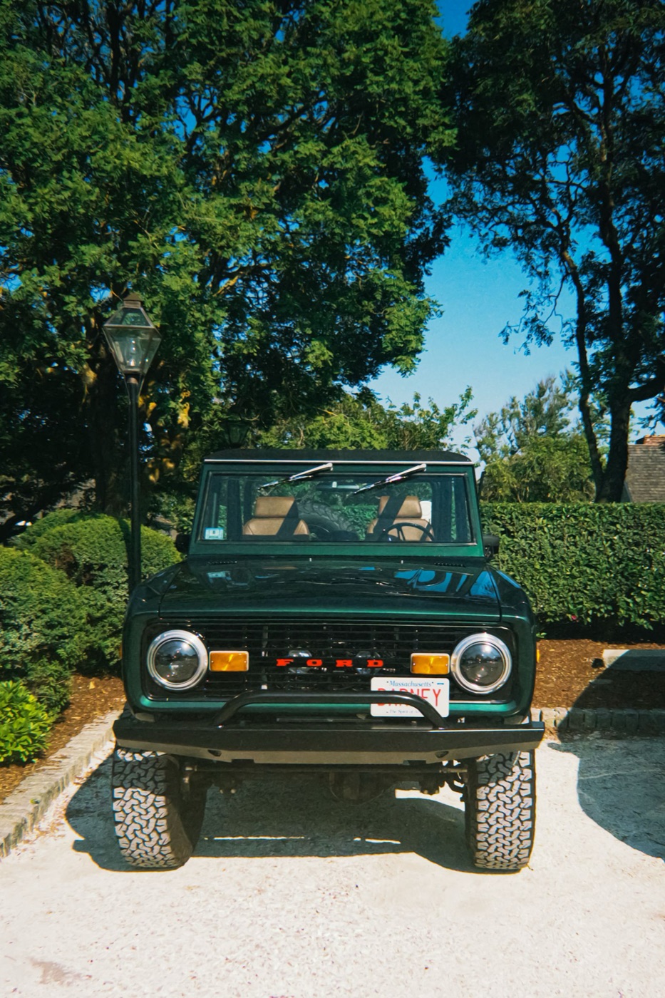 Green first-generation Bronco parked in a park